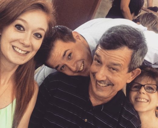 11148649_10206703516803709_8625485077082742672_n A family selfie with two young adults and parents laughing together, capturing a candid and joyful moment.